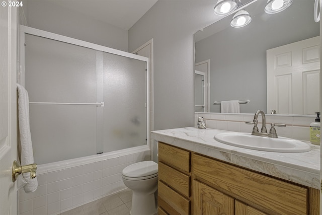 full bathroom featuring enclosed tub / shower combo, tile patterned flooring, vanity, and toilet