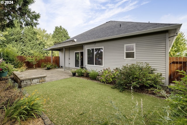 rear view of property featuring a patio and a yard