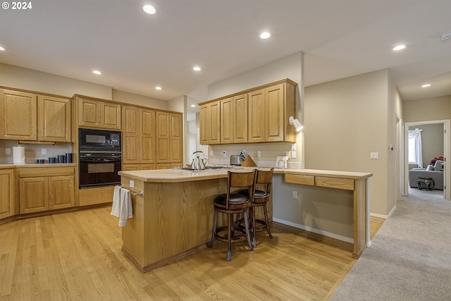 kitchen featuring light colored carpet, kitchen peninsula, a kitchen breakfast bar, and black appliances