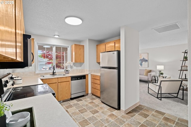 342 NW Denton Ave, Dallas, OR 97338 - kitchen featuring stainless steel appliances, a sink, light countertops, light stone finish flooring, and a textured ceiling