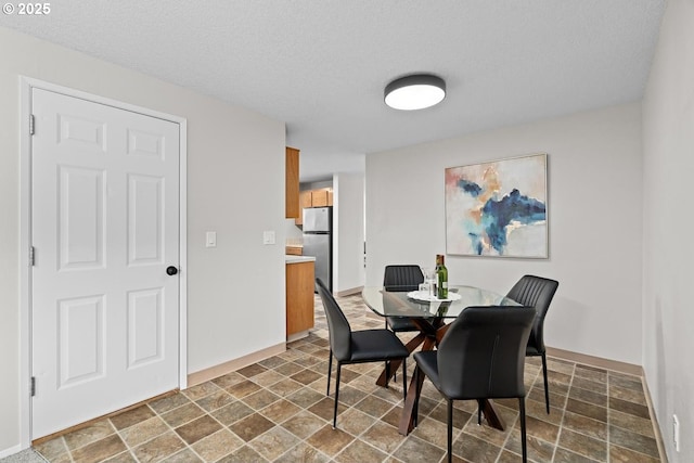 342 NW Denton Ave, Dallas, OR 97338 - dining room featuring stone finish flooring, baseboards, and a textured ceiling