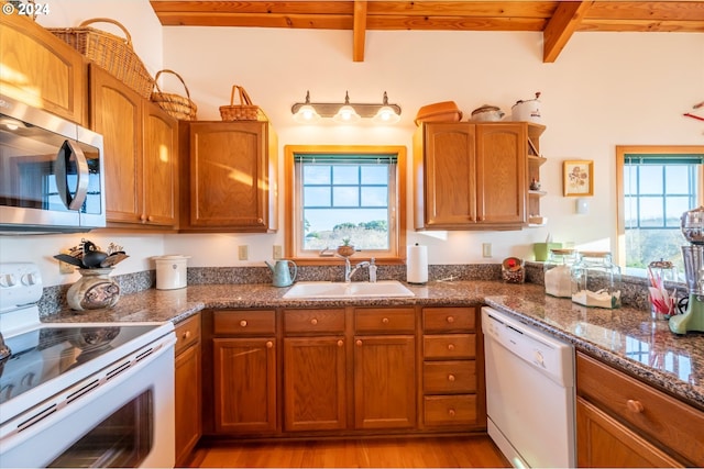 kitchen with sink, white appliances, light hardwood / wood-style flooring, wooden ceiling, and beamed ceiling