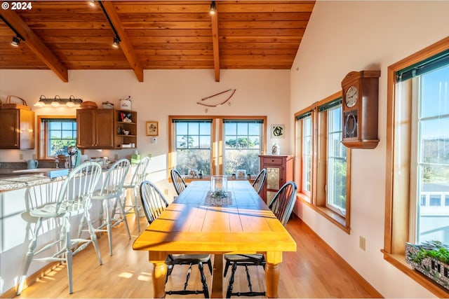 dining space featuring vaulted ceiling with beams, track lighting, wood ceiling, and light hardwood / wood-style floors