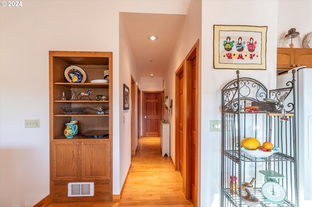 hallway with built in features and light wood-type flooring