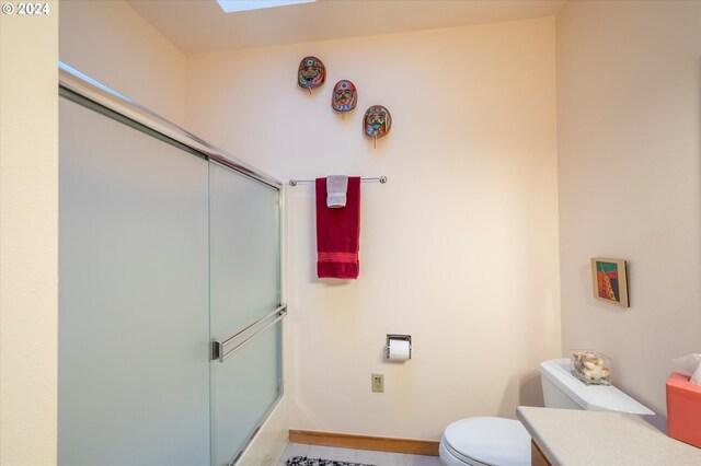 bathroom featuring a skylight and toilet