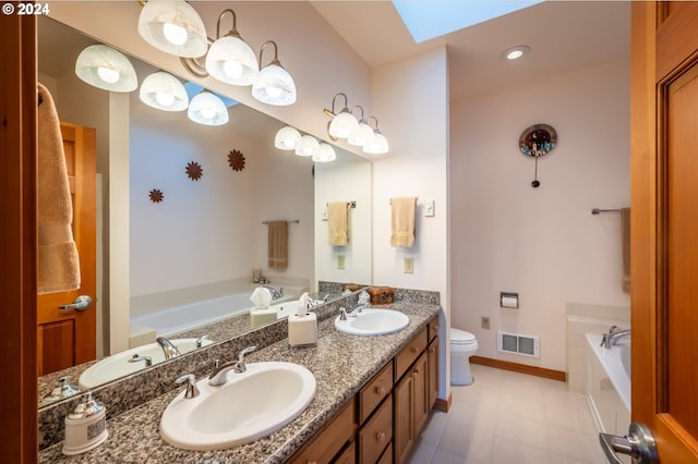 bathroom featuring a bathing tub, toilet, vanity, and a skylight