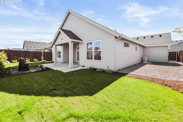 back of house with a patio area and a yard