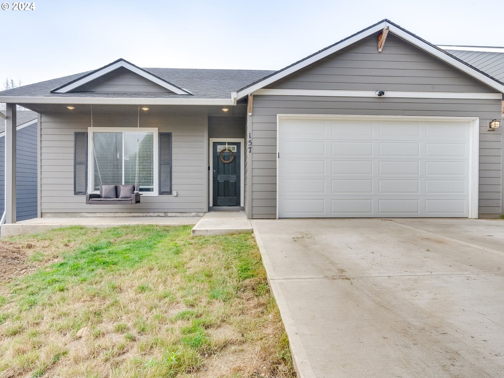 ranch-style house featuring a garage and a front lawn