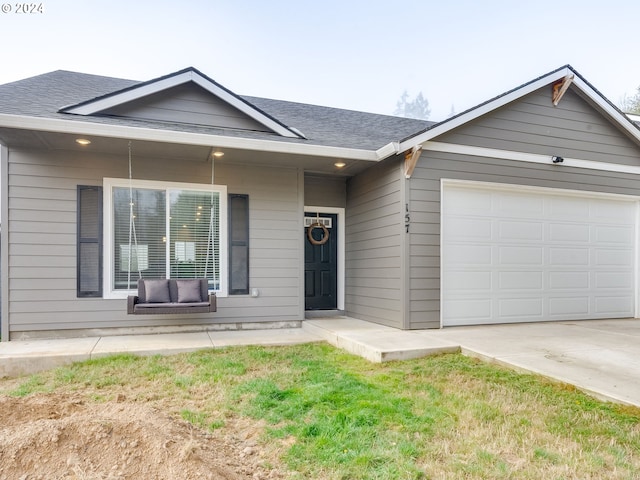 single story home with a garage and a front lawn