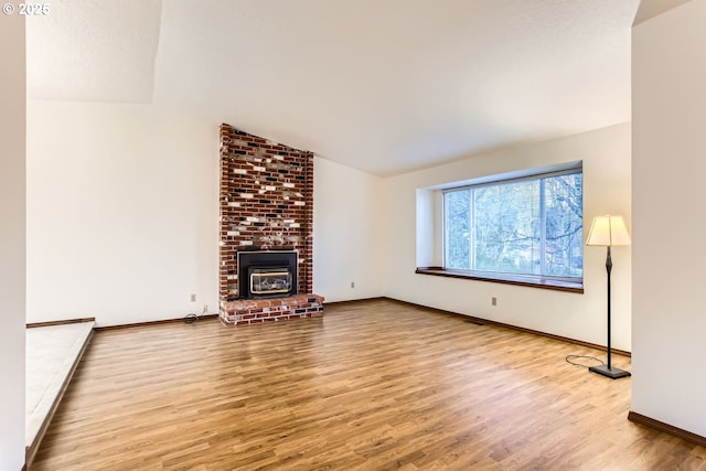 unfurnished living room featuring vaulted ceiling and light hardwood / wood-style flooring