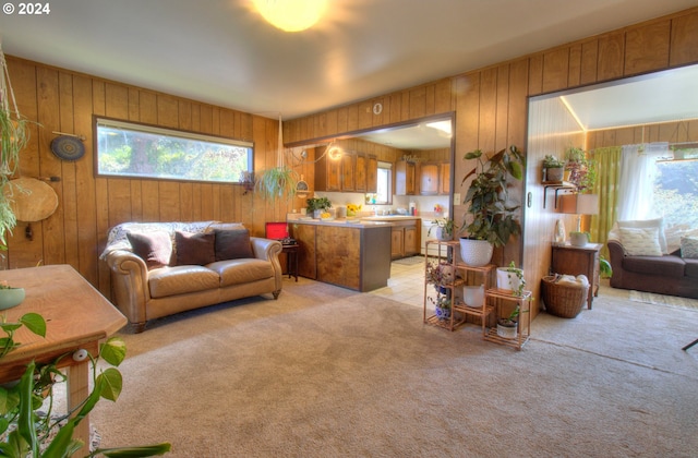 carpeted living room featuring wood walls