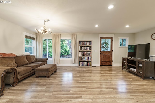 living room with light hardwood / wood-style flooring and an inviting chandelier