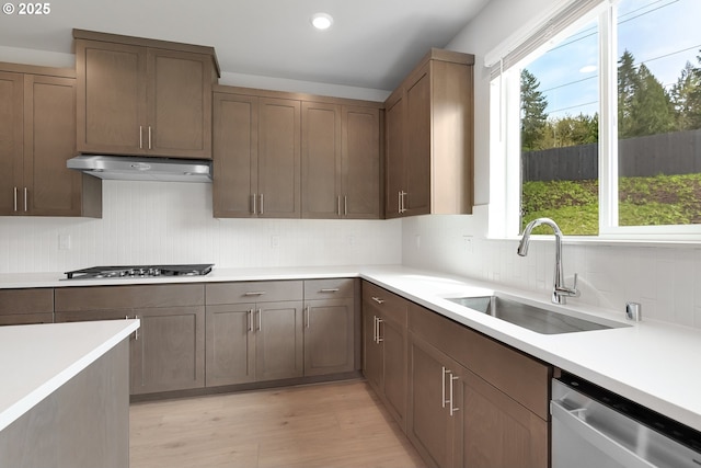 16701 NE 38th Ave, Vancouver, WA 98686 - kitchen with stainless steel appliances, under cabinet range hood, backsplash, a sink, and light wood-style floors