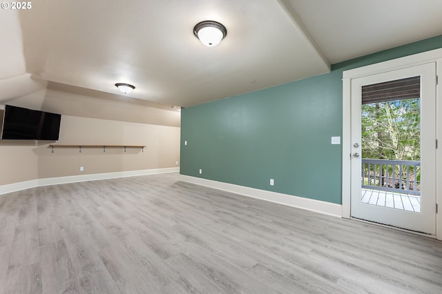 unfurnished living room with light wood-type flooring and vaulted ceiling