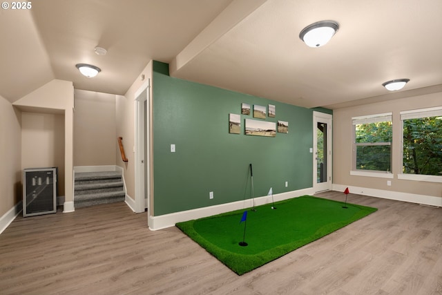 recreation room with wood-type flooring, vaulted ceiling, and beverage cooler