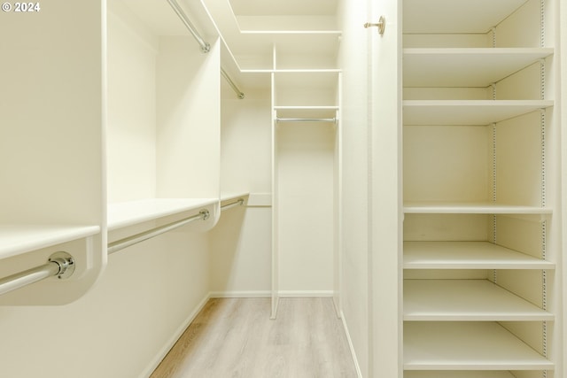 walk in closet with light wood-type flooring