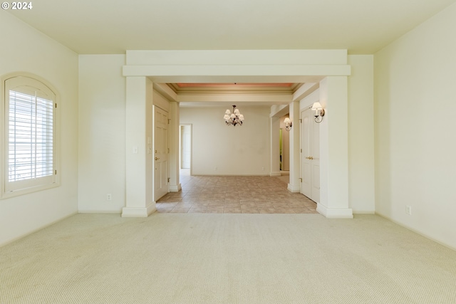 unfurnished room with a chandelier and light colored carpet