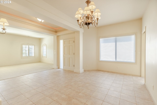 unfurnished room with crown molding, an inviting chandelier, and light tile patterned floors