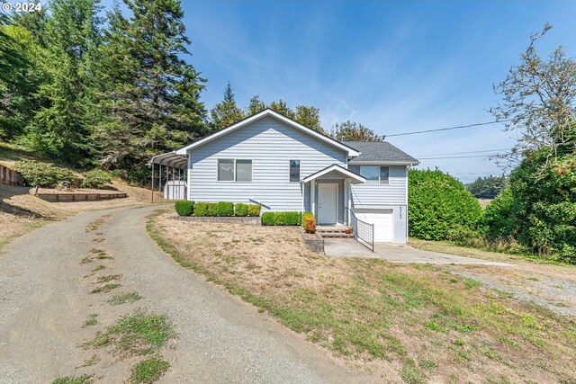 view of front facade with a front yard, a garage, and a carport