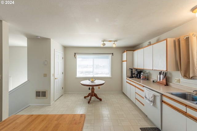 kitchen with white cabinetry, a textured ceiling, dishwasher, heating unit, and sink