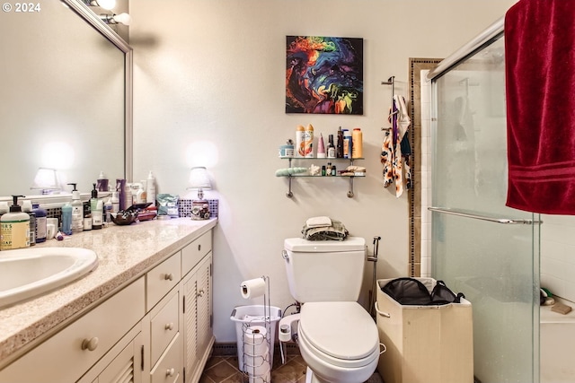 bathroom with tile patterned floors, toilet, vanity, and walk in shower