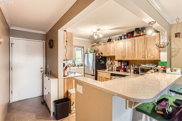 kitchen featuring a kitchen breakfast bar, stainless steel fridge, kitchen peninsula, and ornamental molding