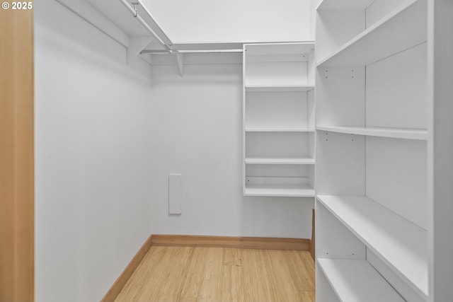 walk in closet with hardwood / wood-style flooring