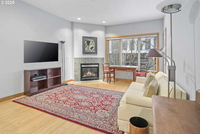 living room featuring hardwood / wood-style flooring and a tiled fireplace