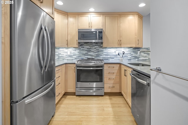 kitchen with backsplash, light brown cabinets, appliances with stainless steel finishes, and sink