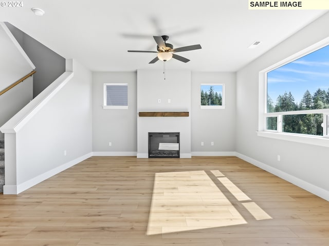 unfurnished living room with ceiling fan and light wood-type flooring