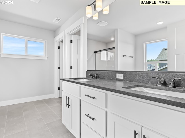 bathroom featuring tile patterned floors, vanity, and a shower with door