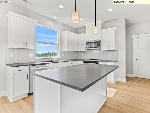 kitchen with light hardwood / wood-style flooring, white cabinets, decorative light fixtures, and appliances with stainless steel finishes