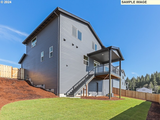 rear view of property with a lawn and a balcony