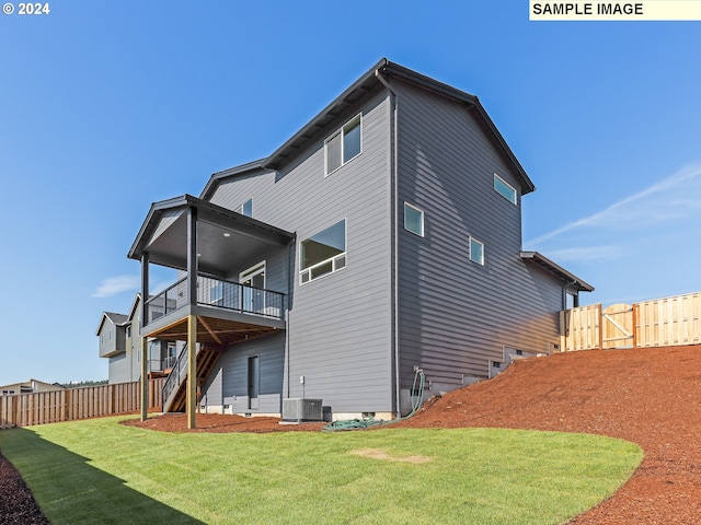 rear view of house with a yard, a balcony, and central air condition unit