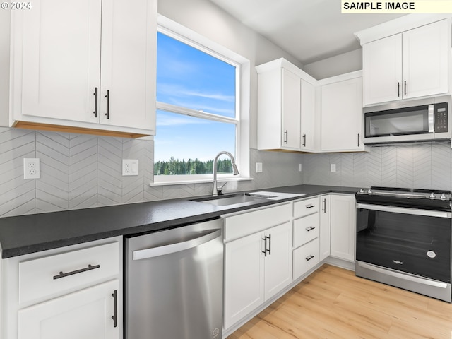 kitchen with decorative backsplash, white cabinets, stainless steel appliances, and light wood-type flooring