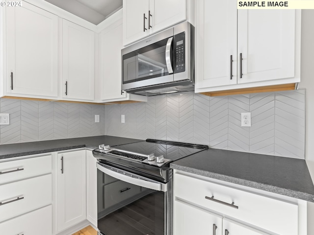 kitchen with white cabinets, light wood-type flooring, stainless steel appliances, and tasteful backsplash