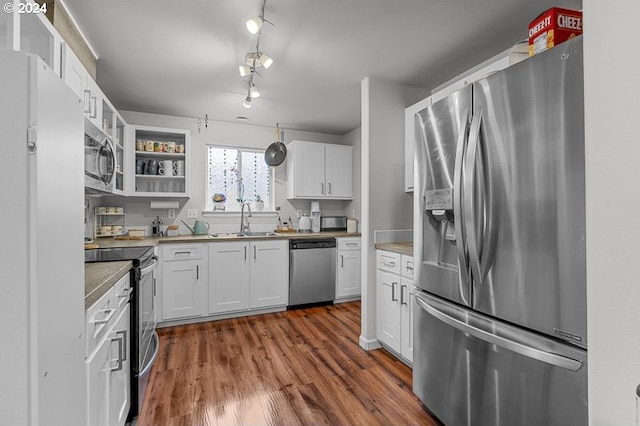 kitchen with track lighting, white cabinets, sink, dark hardwood / wood-style floors, and appliances with stainless steel finishes