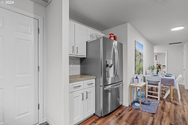 kitchen featuring stainless steel refrigerator with ice dispenser, dark hardwood / wood-style floors, and white cabinetry