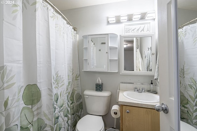 bathroom with a shower with curtain, vanity, and toilet