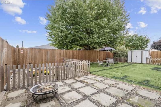 view of patio featuring a shed and a fire pit