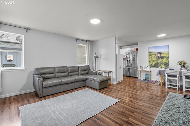 living room featuring dark hardwood / wood-style flooring and a healthy amount of sunlight