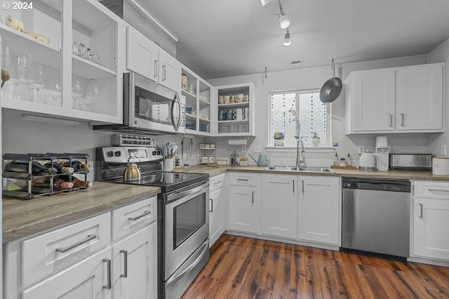 kitchen featuring stainless steel appliances, white cabinetry, dark wood-type flooring, and sink