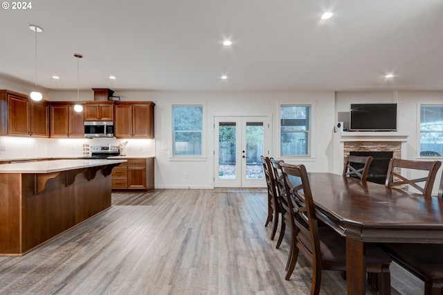 kitchen with hanging light fixtures, french doors, stainless steel appliances, and plenty of natural light