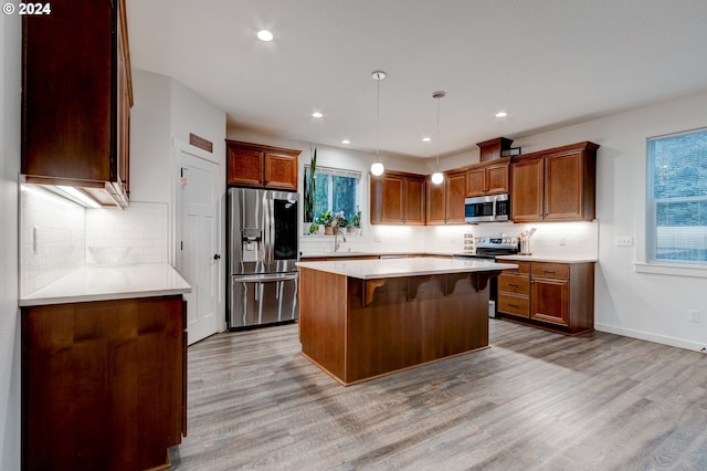 kitchen featuring a wealth of natural light, light wood-type flooring, and appliances with stainless steel finishes