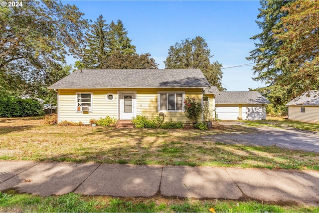 view of front of house featuring an outbuilding and a front lawn