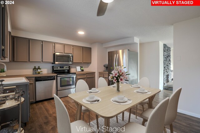 kitchen featuring sink, dark hardwood / wood-style floors, ceiling fan, a textured ceiling, and stainless steel appliances