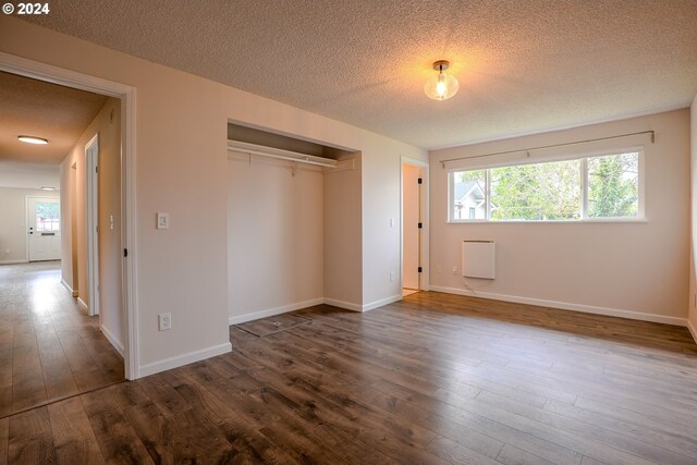 unfurnished bedroom featuring wood-type flooring, a textured ceiling, and a closet