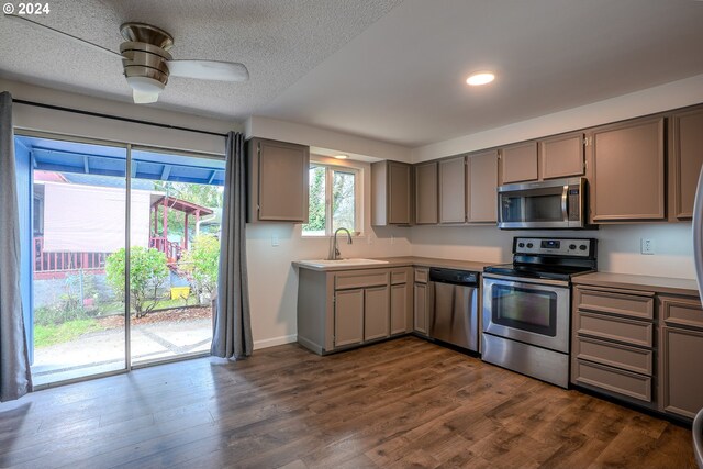 kitchen with gray cabinetry, dark wood-type flooring, sink, ceiling fan, and appliances with stainless steel finishes