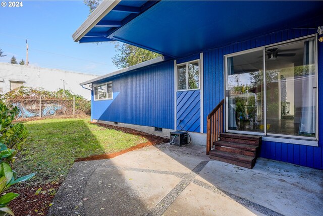 entrance to property with a patio and a lawn