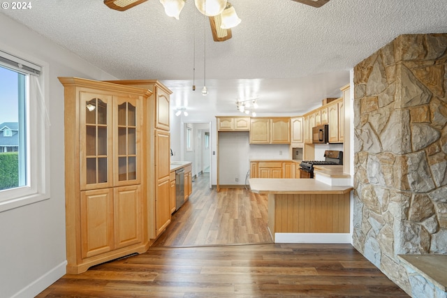 kitchen featuring dark wood-type flooring, black appliances, a textured ceiling, light brown cabinetry, and kitchen peninsula